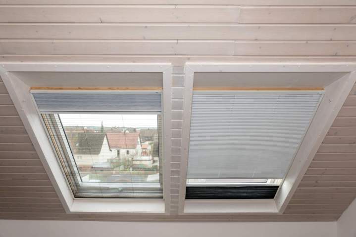 Intérieur dune pièce sous les combles avec une grande fenêtre de toit VELUX apportant une lumière abondante.
